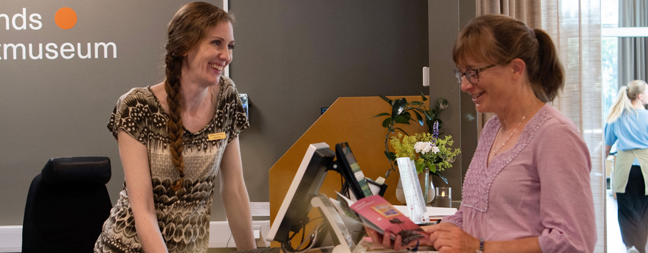 Receptionist som samtalar med besökare.